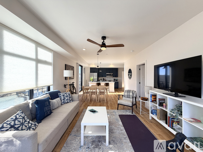 A living room with a white sofa, a coffee table, and a ceiling fan.