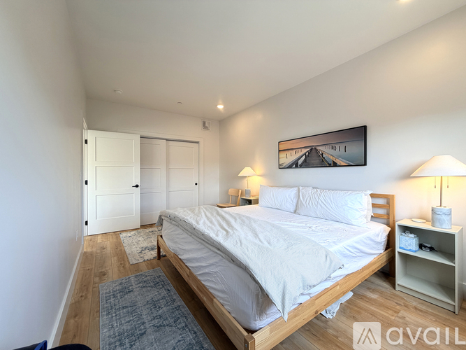 A bedroom with a large bed and a painting on the wall.