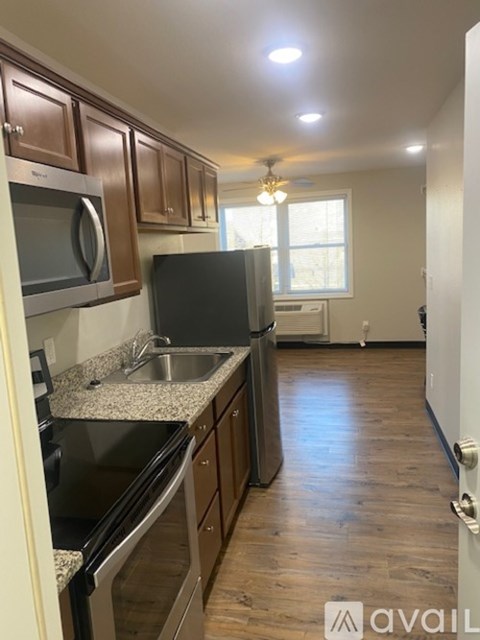 A kitchen with wooden cabinets and a black fridge.