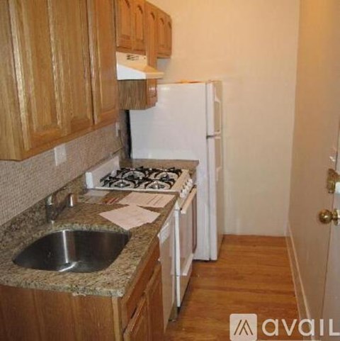 A kitchen with wooden cabinets and a white fridge.