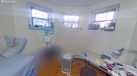 A bedroom with a bed, desk, and window.