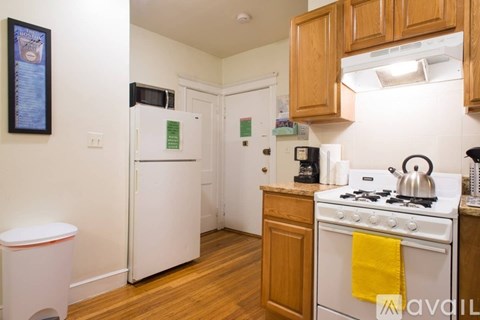 A kitchen with white appliances and wooden cabinets.