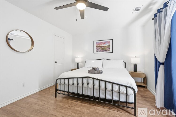 A bedroom with a large bed and a ceiling fan.