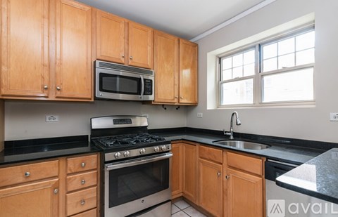 A kitchen with wooden cabinets and a black countertop.
