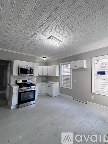 A kitchen with a tile ceiling and a stove top oven.