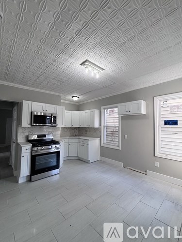 A kitchen with a tile ceiling and a stove top oven.