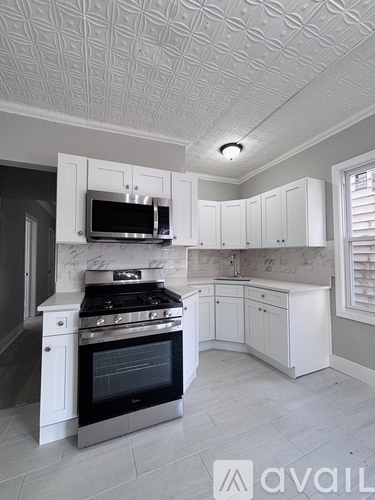 A kitchen with white cabinets and a black oven.