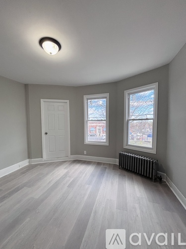 A room with a grey floor and a window showing a snowy landscape outside.