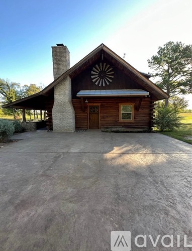 A wooden house with a large front porch and a stone chimney.