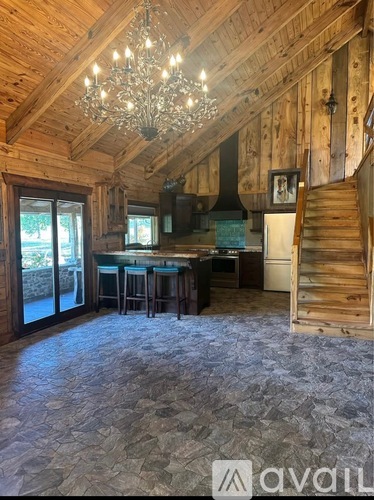 A large open space with a bar and stairs leading to another level.