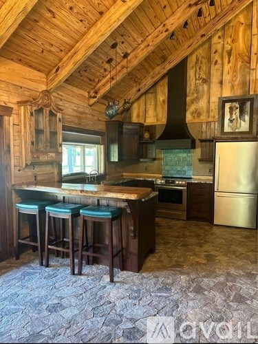 A kitchen with wooden cabinets and a stone floor.