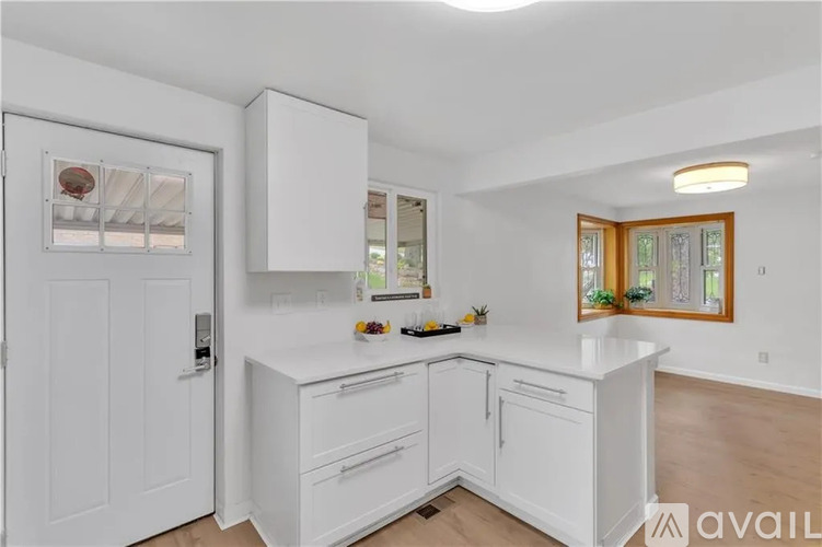 A kitchen with white cabinets and a window.