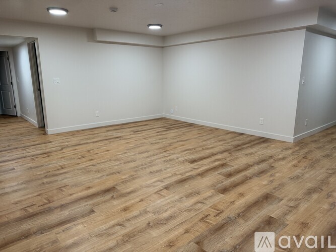 A room with wooden flooring and white walls.