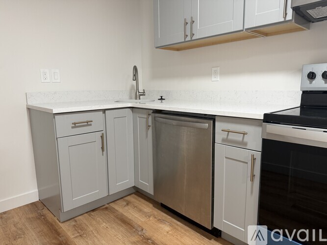 A kitchen with a white countertop and grey cabinets.