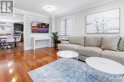 A living room with a couch, a television, and a painting on the wall.