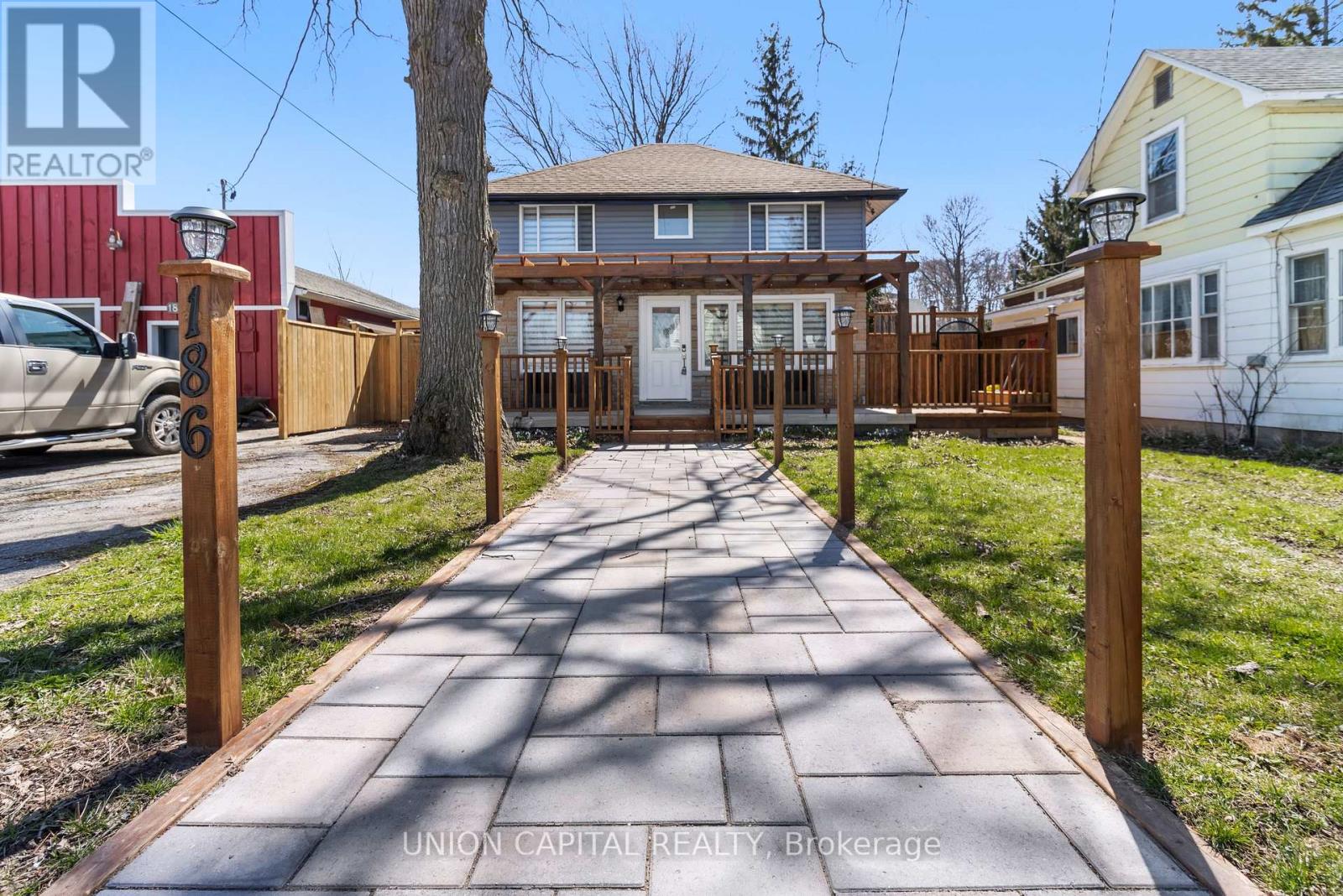 A house with a wooden fence and a walkway in front of it.