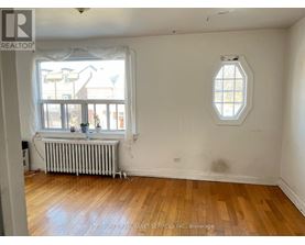 A room with a window and a wooden floor.