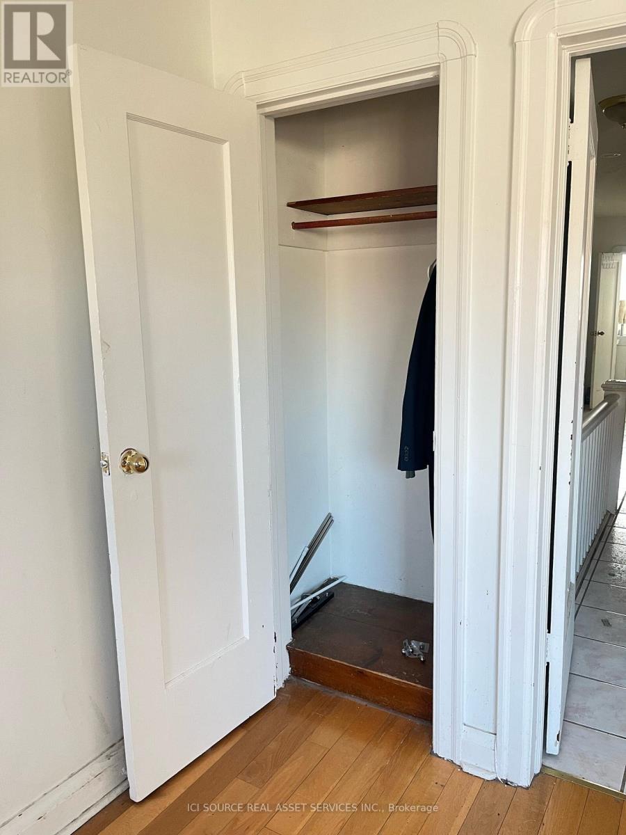 A white door with a black coat hanging on a hook.