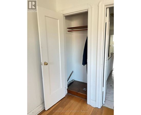 A white door with a black coat hanging on a hook.