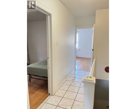 A bedroom with a bed and a toilet paper holder.