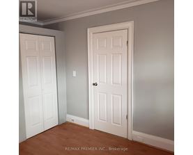 A room with two doors and a brokerage sign.