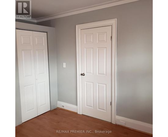 A room with two doors and a brokerage sign.