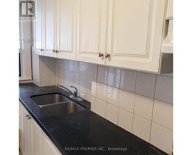 A kitchen with white cabinets and a black counter top.