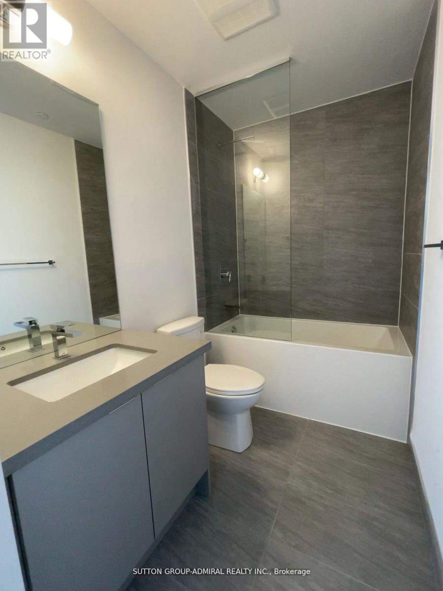 A bathroom with a toilet, sink, and shower.