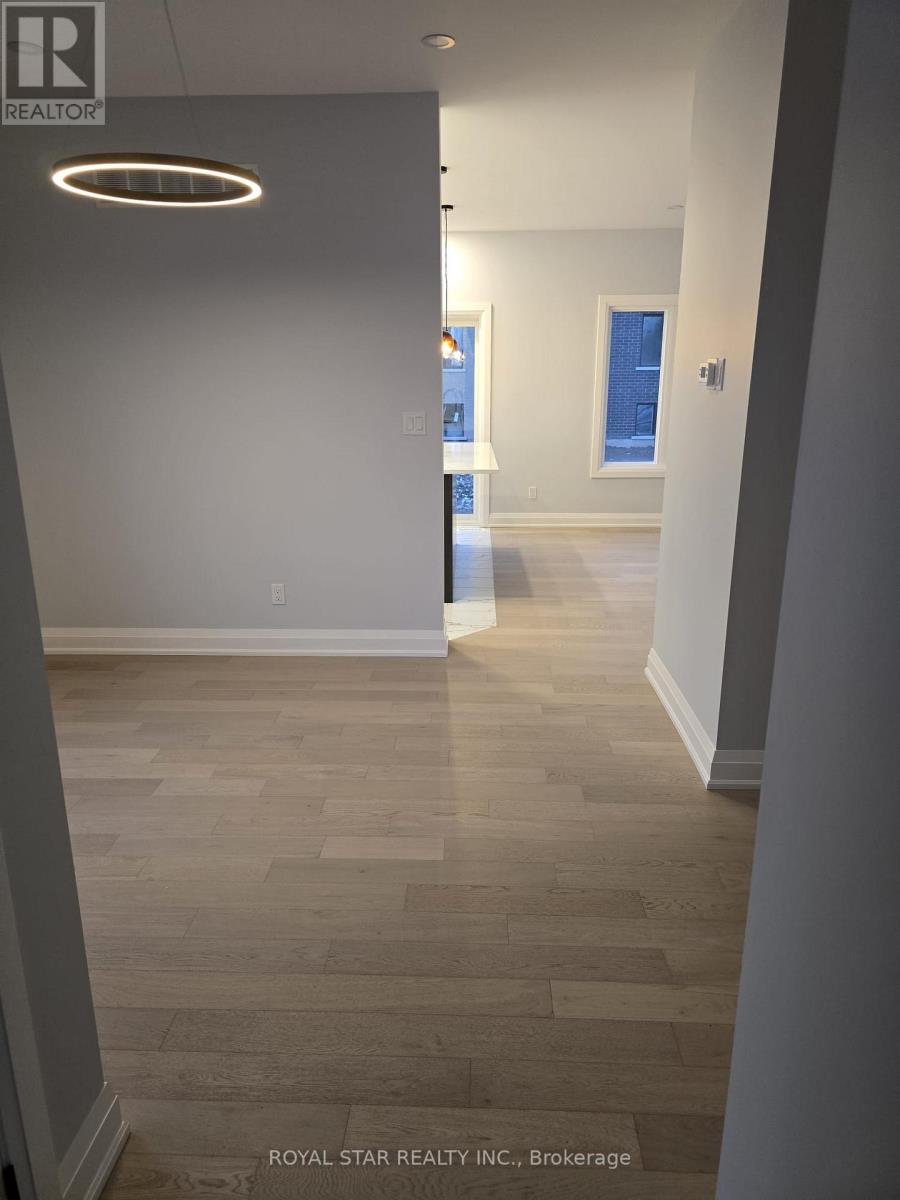 A hallway with a light on the ceiling and a brokerage sign on the wall.