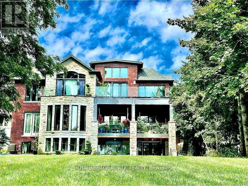 A large, multi-level house with a balcony and a large front yard.