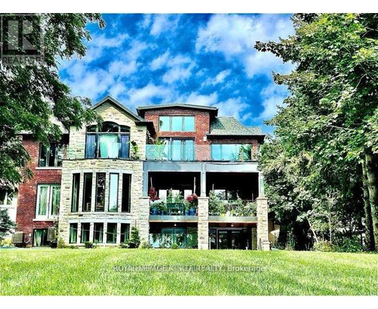 A large, multi-level house with a balcony and a large front yard.