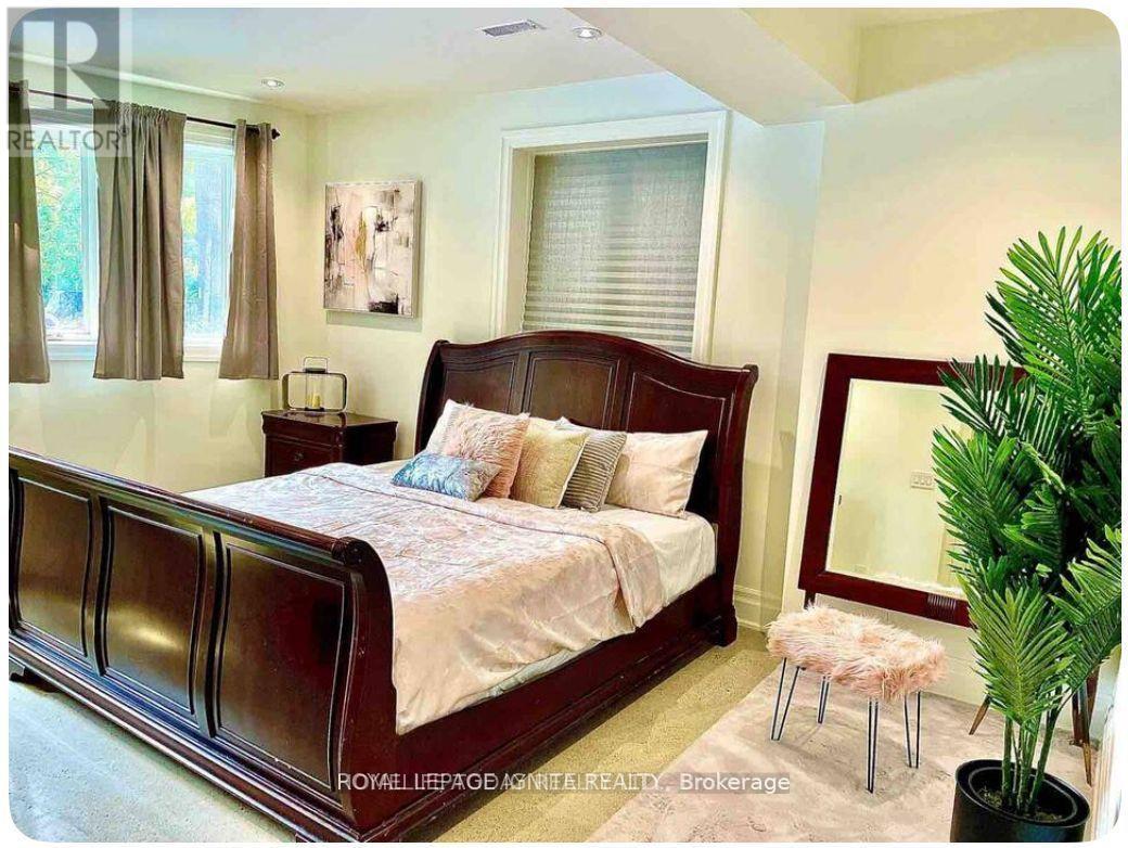 A bedroom with a large bed and a potted plant.