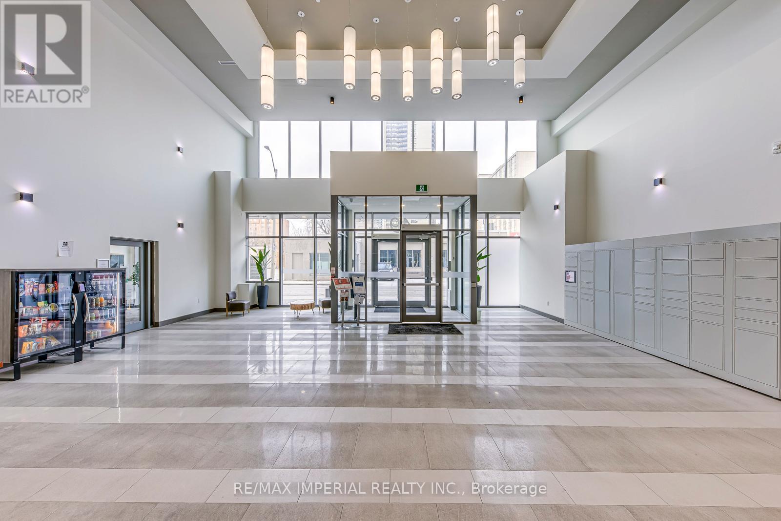 A spacious lobby with a reception desk and a large glass window.