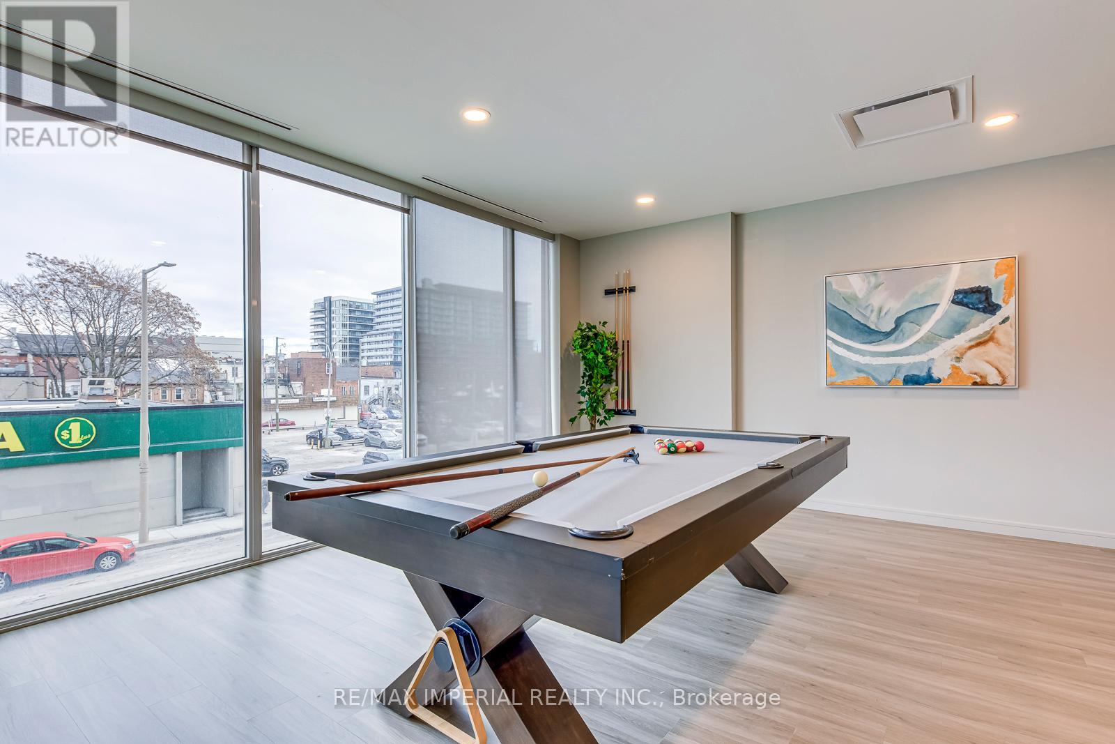 A pool table in a room with a view of a street outside.