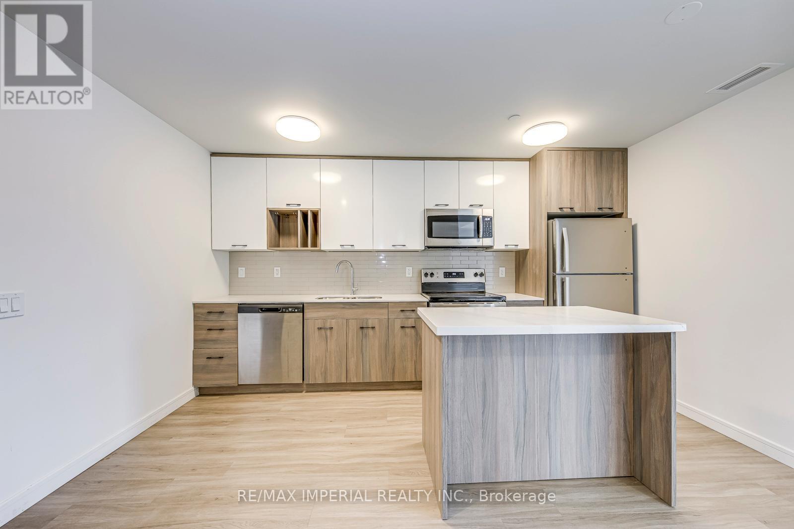 A kitchen with white cabinets and a wooden island.