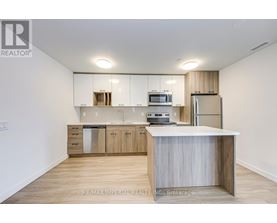 A kitchen with white cabinets and a wooden island.