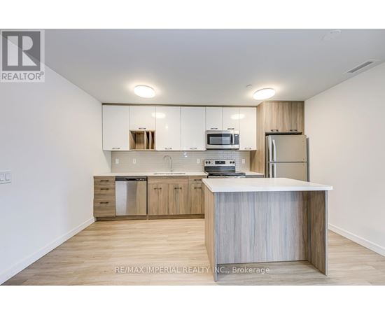 A kitchen with white cabinets and a wooden island.