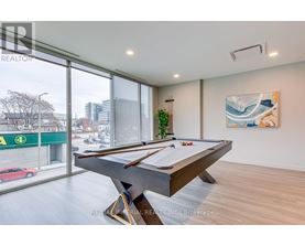 A pool table in a room with a view of a street outside.