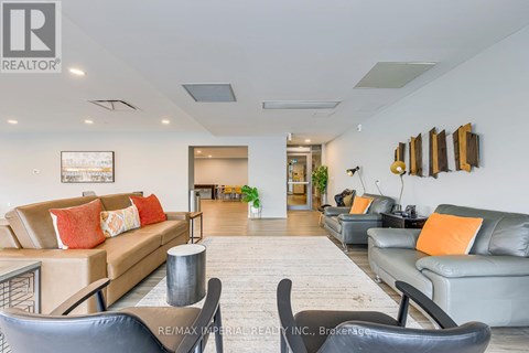 A living room with a couch, chairs, and a painting on the wall.