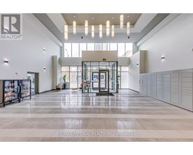 A spacious lobby with a reception desk and a large glass window.