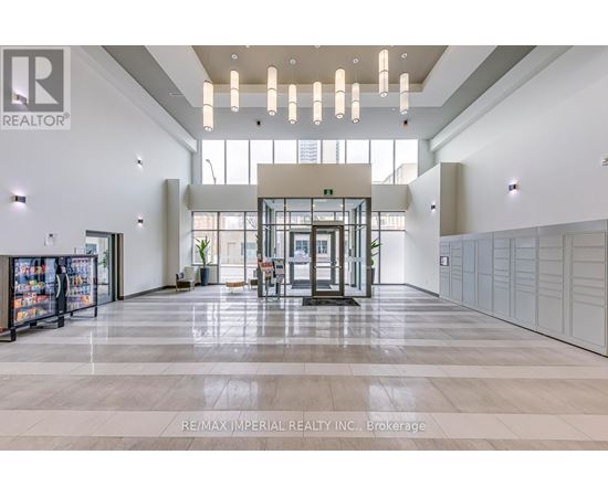 A spacious lobby with a reception desk and a large glass window.