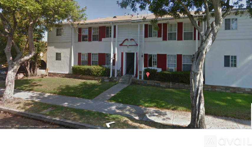 A white building with red trim and a red awning.