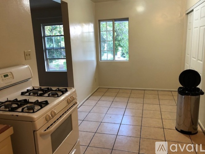 A kitchen with a white stove and a window.