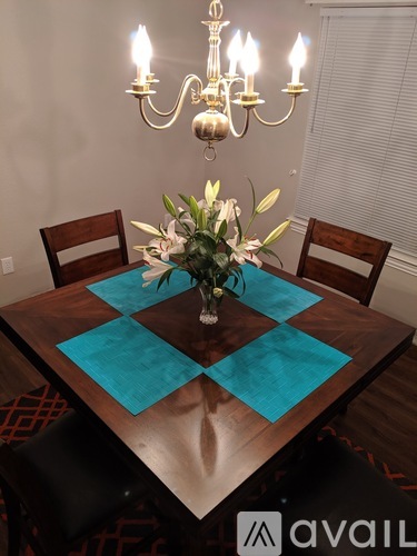 A dining table with a vase of flowers on it.