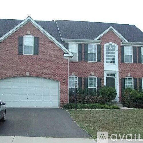A red brick house with a white garage door.