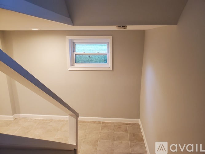 A small window in a room with a tiled floor.