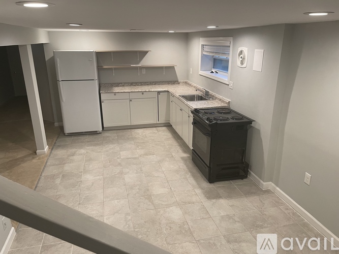 A kitchen with a black stove top oven and white cabinets.