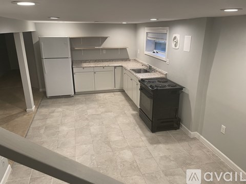 A kitchen with a black stove top oven and white cabinets.