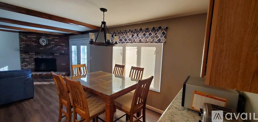 A dining room with a wooden table and chairs.