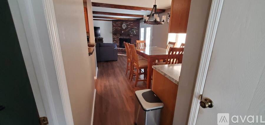 A kitchen with a dining table and chairs is visible from the hallway.